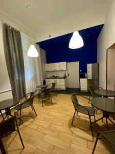 a dining room with tables and chairs and a kitchen at SKY HOSTEL in Krakow