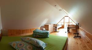 a bedroom with a green bed and a staircase at Kempings ĒRGĻI in Bernāti