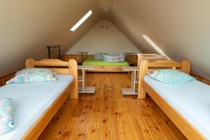a room with three beds in a attic at Ērgļi in Bernāti