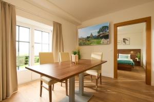 a dining room with a wooden table and chairs at Haus Aussicht - Ferienwohnungen Velden in Velden am Wörthersee