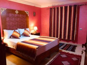 a bedroom with a large bed with red walls at Dar Rehab in Rabat
