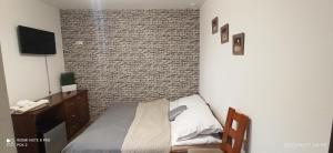 a bedroom with a bed and a wall with a television at Apartamenty Puk Puk in Mrągowo