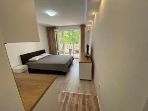 a small bedroom with a bed and a window at Студио Симона 3 - първа линия море in Lozenets +12 photos