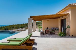 a villa with a patio and a swimming pool at Terra Lucis Mountain Residences in Agios Leon