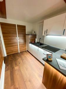 een keuken met witte kasten en een houten vloer bij SH Porto 1 Floating House, Marina Portorož in Portorož