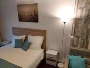a small bedroom with a bed and a lamp at Bike & Spa Velence Apartman in Velence