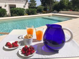 a table with a blue vase and some fruit and drinks at Casa 34 in Ceglie Messapica