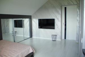 a bedroom with a bed and a television on the wall at SEALEO in Gribovka