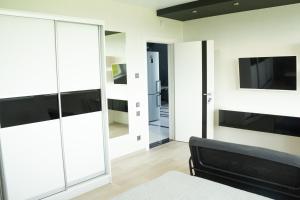a bedroom with sliding glass doors and a black couch at SEALEO in Gribovka