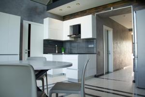a kitchen with white cabinets and a table and chairs at SEALEO in Gribovka