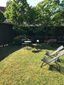 twee stoelen en een tafel in de tuin bij Appartement Cosy, tout confort, à deux pas de la mer in Deauville