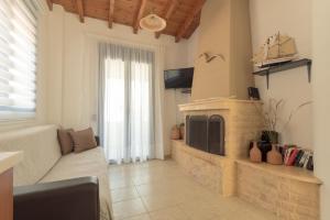 a living room with a fireplace and a couch at Sunset Home Crete in Paránimfoi