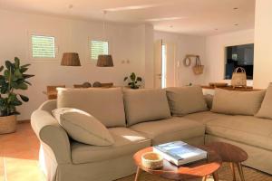 un soggiorno con divano e tavolo di LLEBEIG -Casa mediterránea con gran jardín a Cadaqués