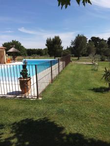 une clôture en face d'une piscine dans l'établissement Gite La RESTANCO, à Mouriès