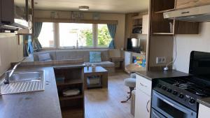 una pequeña cocina y sala de estar en una caravana en RBR 1021 - Beach Resort Kamperland, en Kamperland