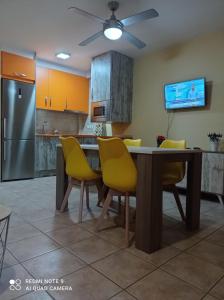 アロヨ・フリオにあるVivienda rodriguezのキッチン(ダイニングルームテーブル、黄色い椅子付)