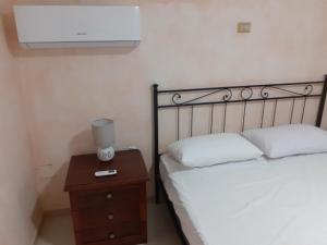 een slaapkamer met een bed en een nachtkastje met een bed sidx sidx sidx sidx bij COUNTRY HOUSE in Mafalda