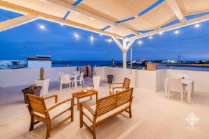 a rooftop patio with tables and chairs and a view of the ocean at Almanzar - Residenze sul mare in Lampedusa