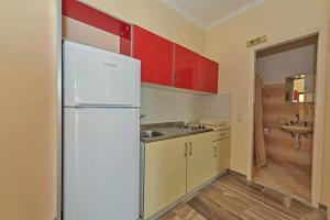 a kitchen with a white refrigerator and a sink at Seafront Apartments in Kavos