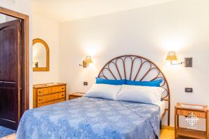 a bedroom with a bed with a blue comforter at Almanzar - Residenze sul mare in Lampedusa