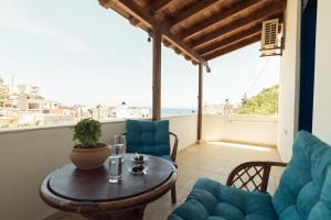 a living room with a table and chairs on a balcony at Sunset Home Crete in Paránimfoi