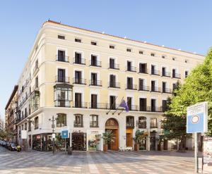 un gran edificio blanco al lado de una calle en Francisco I Boutique en Madrid