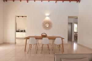 a dining room with a wooden table and white chairs at Ô'Bèl Ter in Pointe-Noire