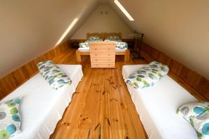 a attic room with two beds and a desk at Ērgļi in Bernāti