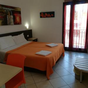 a bedroom with a bed with an orange blanket at La Locanda Del Mare B&B in La Caletta