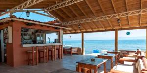 a restaurant with a bar with the ocean in the background at Seafront Apartments in Kavos