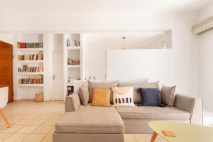 sala de estar con sofá y almohadas en Del Mar Luxury Apartment 30m From The Beach, en Porto Rafti