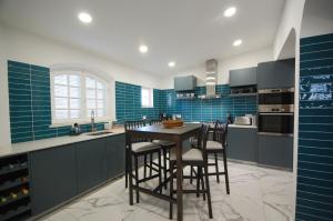 a kitchen with blue tiles and a table with chairs at Qta do Eucalipto Villa in Faro
