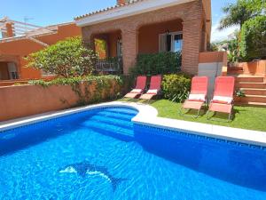 a swimming pool with chairs and a house at Villa with private pool, sea view& turkish sauna in Arroyo de la Miel