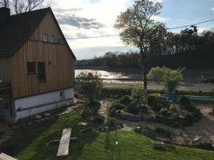 a garden in front of a building with a church at Der Zirkuswagen und das Elfenhaus in Dittmannsdorf