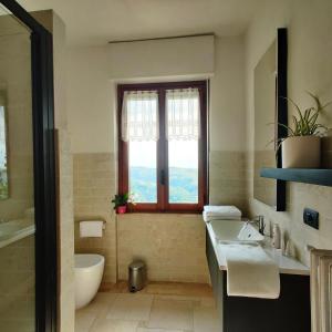 a bathroom with a sink and a tub and a window at Cà ed Michel in Neviglie