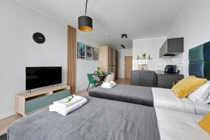 2 camas en una habitación con TV y cocina en Apartament Wałowa Stara Stocznia Gdańsk en Gdansk