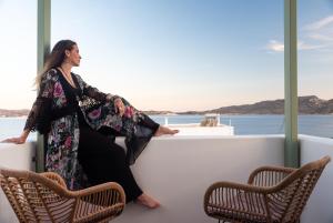 a woman sitting on a balcony on a boat at Eclipse Tales in Adamas