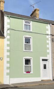a green and white house with two windows at Driftwood House in Portaferry