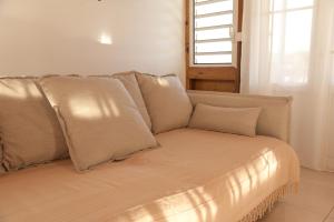 ein Sofa mit Kissen in einem Zimmer mit Fenster in der Unterkunft Ô'Bèl Ter in Pointe-Noire
