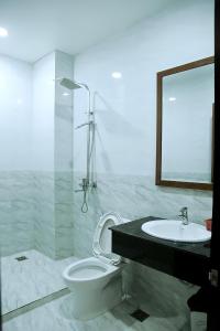 een badkamer met een toilet, een wastafel en een spiegel bij HOTEL ĐĂNG KHOA 2 NÚI SAM in Chau Doc
