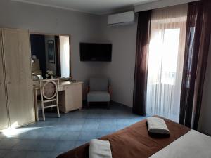 a bedroom with a bed and a desk and a television at Hotel Soleluna in Piano di Sorrento