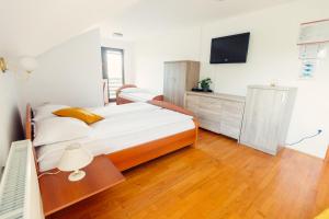 a bedroom with a bed and a tv on the wall at Frankovič Bed&Breakfast in Vinica