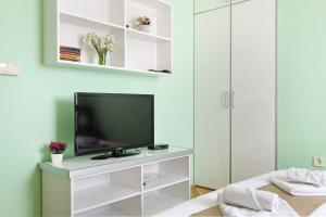 a living room with a television and a dresser at Apartments Bohemia in Zlatibor