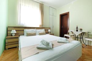 a hotel room with a bed, desk, chair and window at Apartments Bohemia in Zlatibor