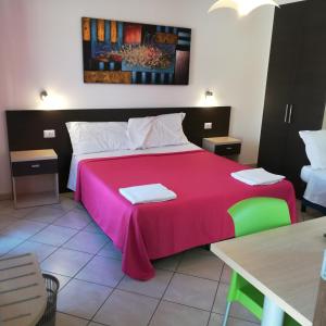 1 dormitorio con 1 cama grande con manta rosa en La Locanda Del Mare B&B, en La Caletta