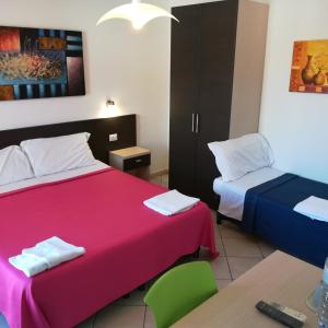 a hotel room with two beds and a table and a desk at La Locanda Del Mare B&B in La Caletta