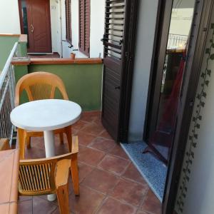 - Balcón con mesa pequeña y 2 sillas en La Locanda Del Mare B&B, en La Caletta