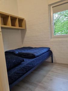 een bed in een kamer met een raam bij Groenpark Simpelveld - Castra 33 in Simpelveld