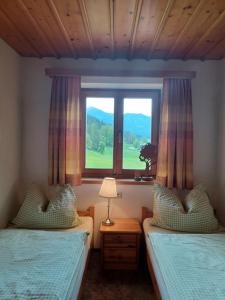 a bedroom with two twin beds and a window at Ferienwohnungen Asterbach in Gosau