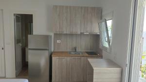 a kitchen with a stainless steel refrigerator and wooden cabinets at Vila Andoni in Qeparo